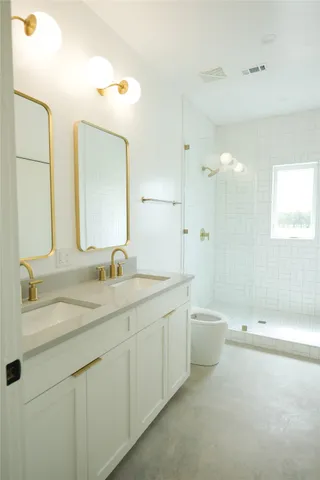 a bathroom with a double vanity sink mirror and a bathtub
