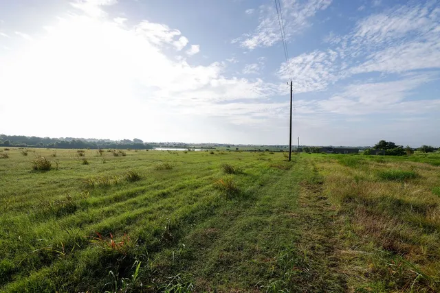 a view of a field with an ocean view