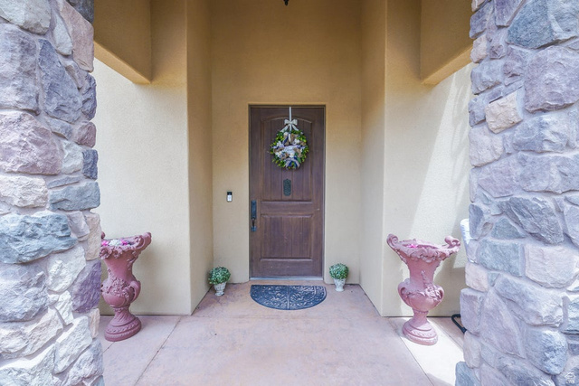 3683 South 2640 West St. George, UT 84790 - Photo 10 of 41 Entryway with stacked stone columns, stucco exterior, and a paneled wood-finish door