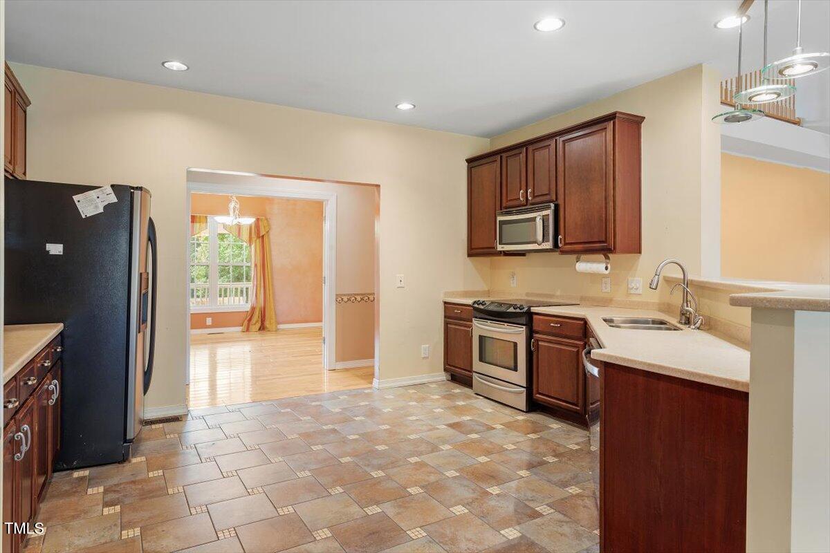 1175 Faulkner Town Road Henderson, NC 27537 - Photo 24 of 48 a kitchen with stainless steel appliances granite countertop a refrigerator and a stove top oven