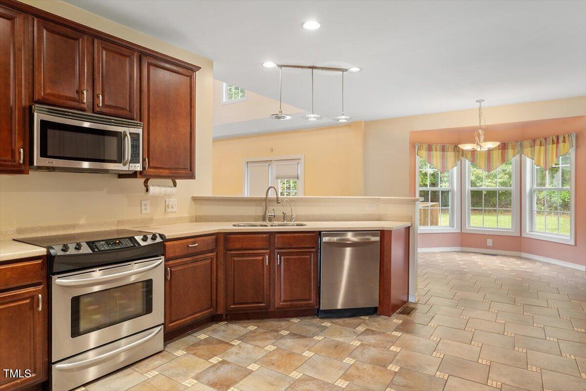 1175 Faulkner Town Road Henderson, NC 27537 - Photo 26 of 48 a kitchen with stainless steel appliances granite countertop a stove top oven a sink and a microwave