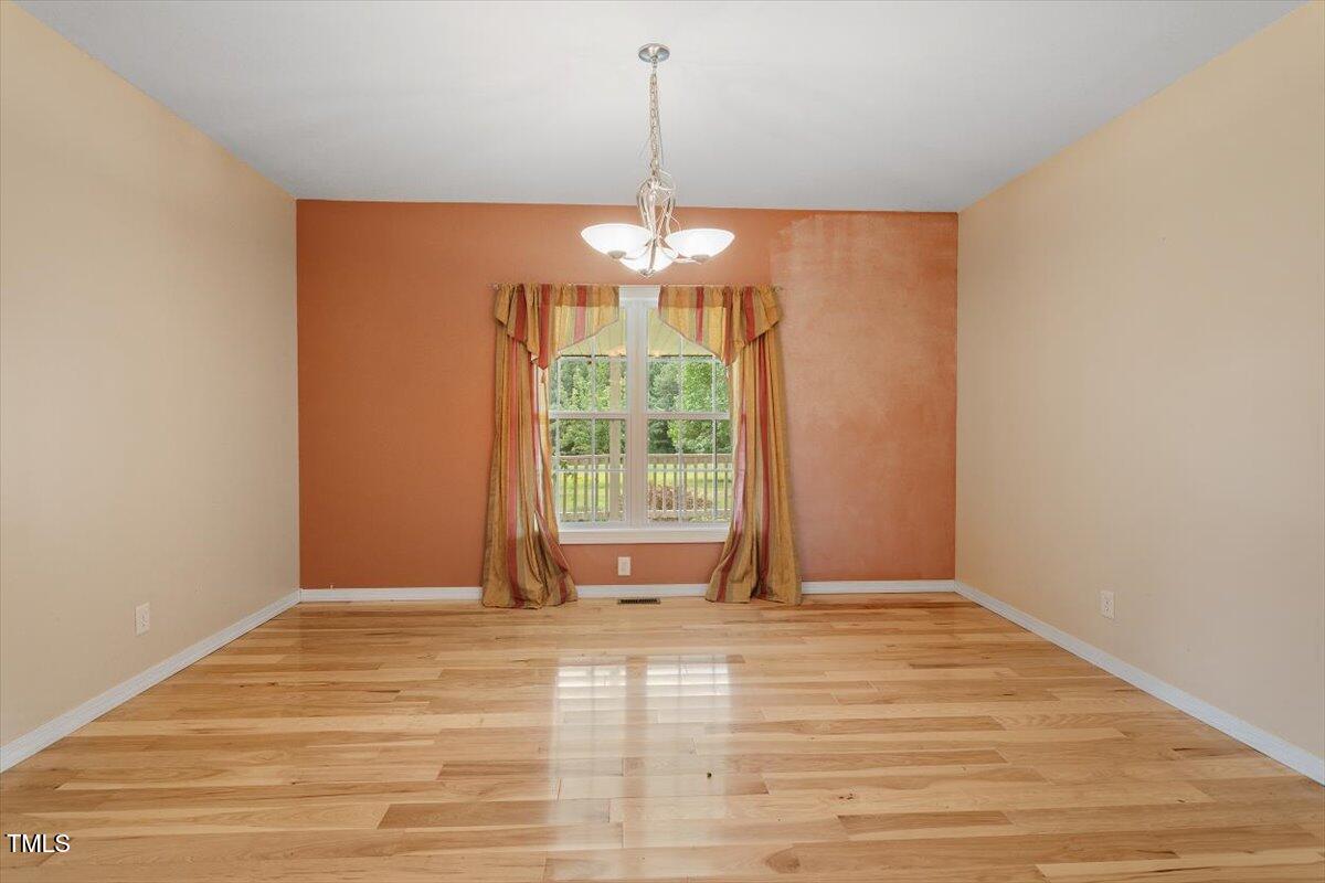 1175 Faulkner Town Road Henderson, NC 27537 - Photo 27 of 48 a view of a room with window wooden floor and a chandelier