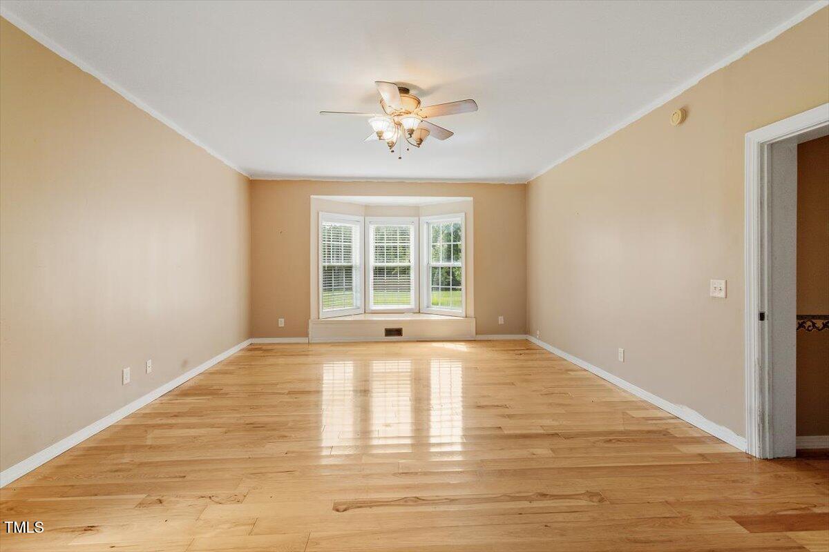 1175 Faulkner Town Road Henderson, NC 27537 - Photo 29 of 48 a view of an empty room with wooden floor and a window