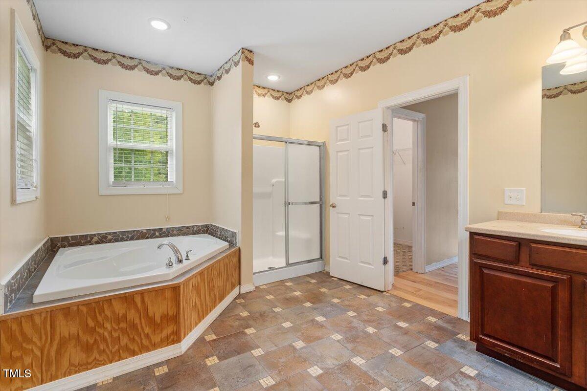 1175 Faulkner Town Road Henderson, NC 27537 - Photo 33 of 48 a spacious bathroom with a tub a sink and a shower