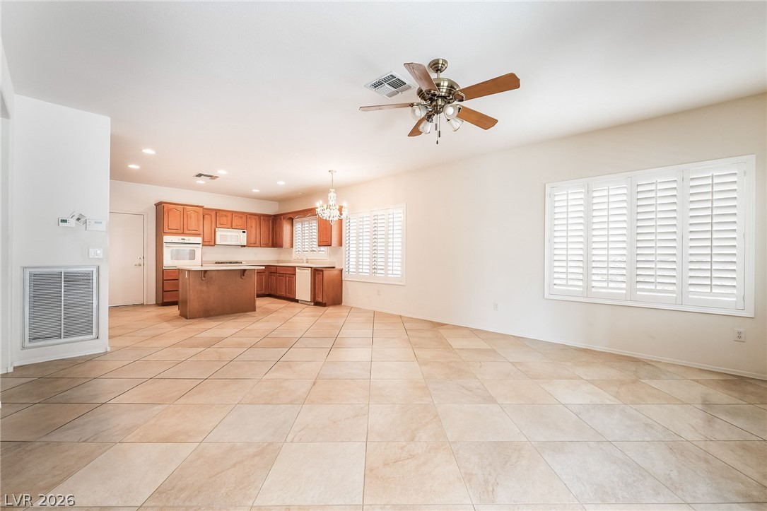 3033 Hartsville Road Henderson, NV 89052 - Photo 15 of 41 An open concept kitchen and living area showcases practical tile flooring and plantation shutters.