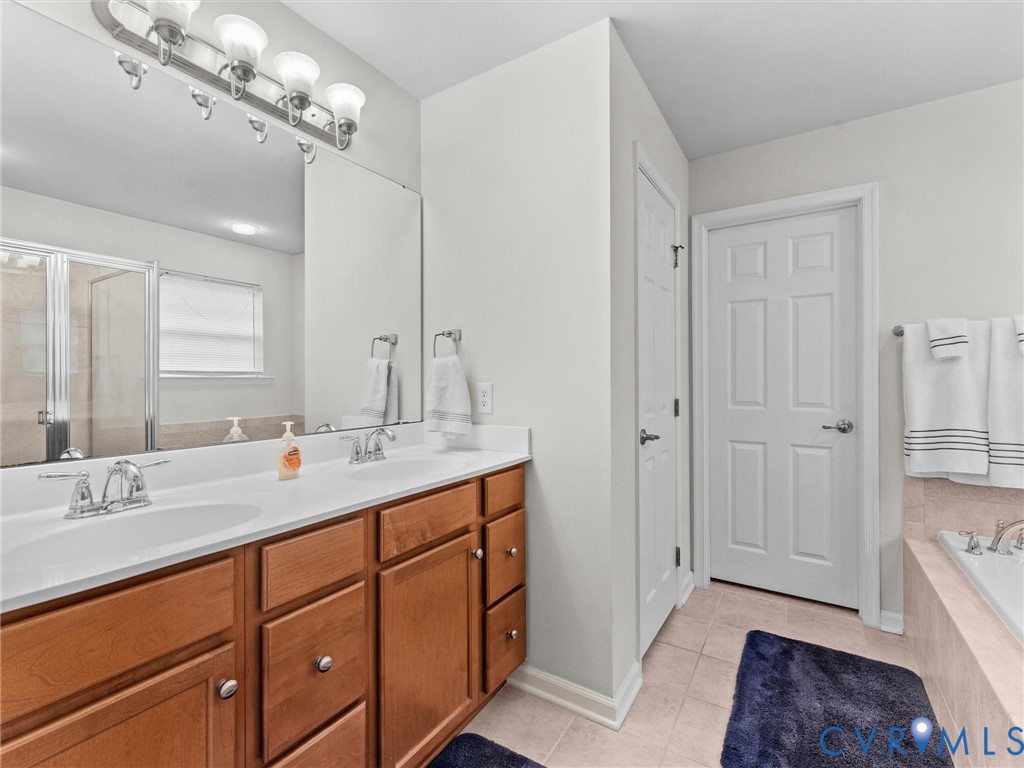 7036 Heartleaf Lane Moseley, VA 23120 - Photo 17 of 28 a spacious bathroom with a double vanity sink double vanity and a mirror