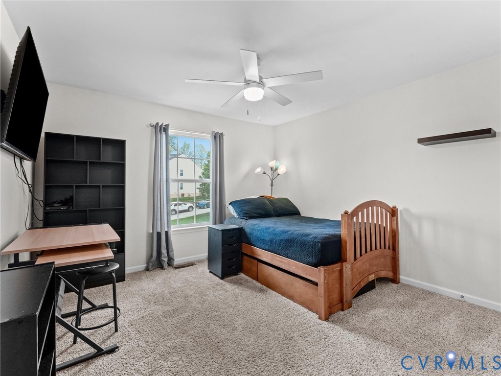 7036 Heartleaf Lane Moseley, VA 23120 - Photo 21 of 28 a bedroom with a bed and a chandelier