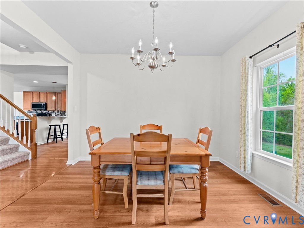 7036 Heartleaf Lane Moseley, VA 23120 - Photo 5 of 28 a view of a dining room with furniture wooden floor and chandelier