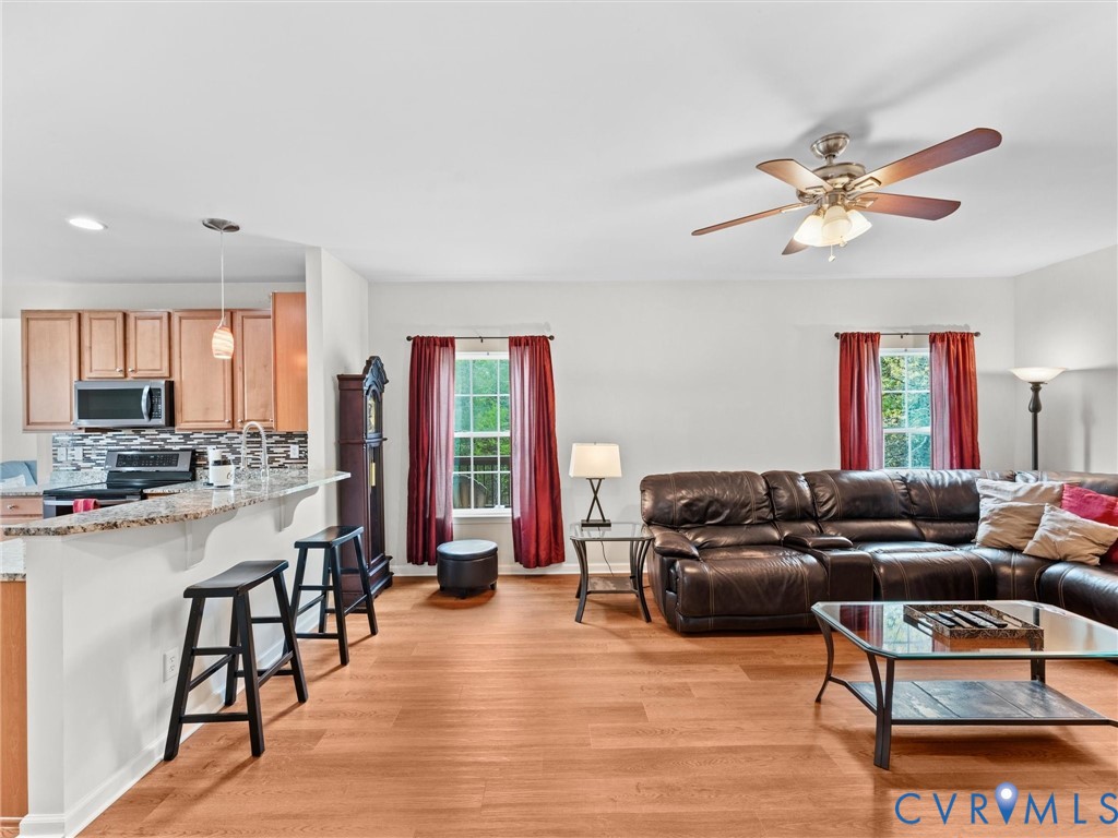 7036 Heartleaf Lane Moseley, VA 23120 - Photo 8 of 28 a living room with furniture a ceiling fan and a window