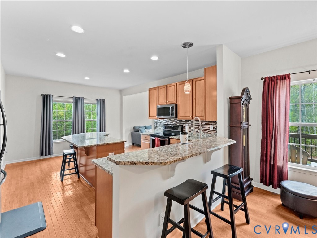 7036 Heartleaf Lane Moseley, VA 23120 - Photo 10 of 28 a dining room with stainless steel appliances granite countertop furniture a fireplace a rug and a large window