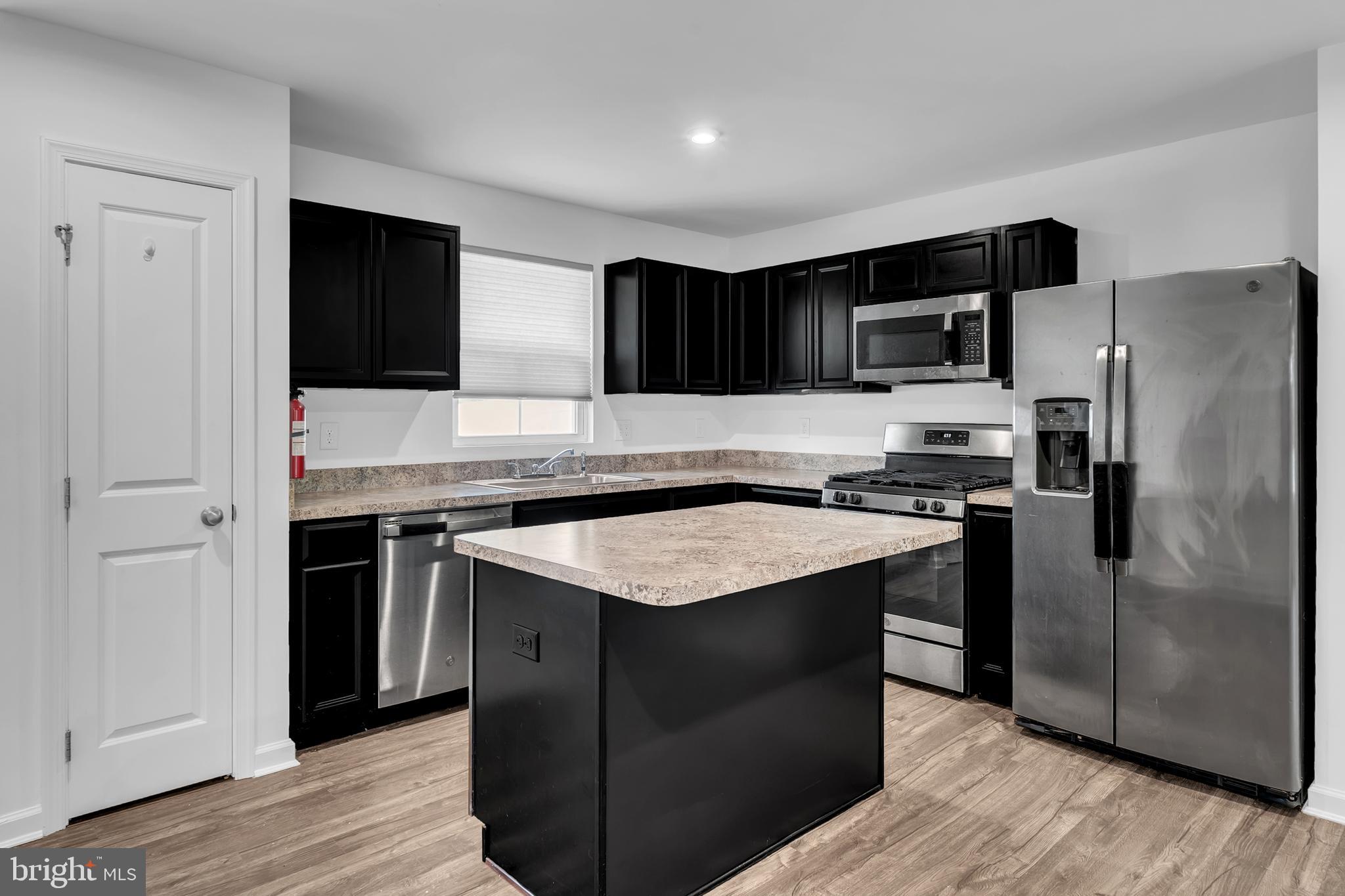 144 Ciseley Drive Sicklerville, NJ 08081 - Photo 18 of 48 a kitchen with kitchen island granite countertop stainless steel appliances and wooden cabinets