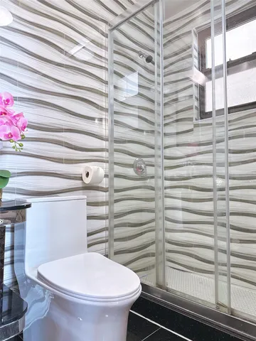 a bathroom with a toilet and a shower