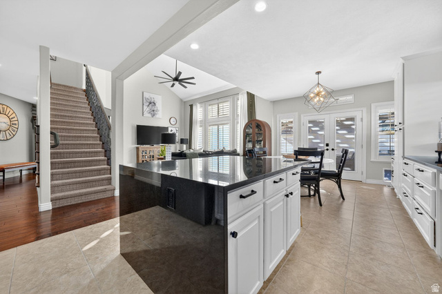 14738 Tangle Hill Road Herriman, UT 84096 - Photo 20 of 66 Kitchen island with a dark countertop and white cabinetry, tile flooring, and a contemporary light fixture