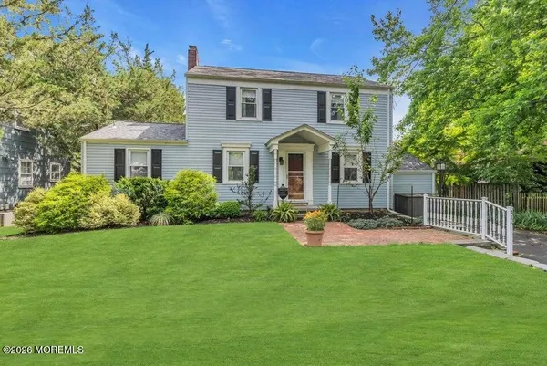 a front view of a house with a yard and trees