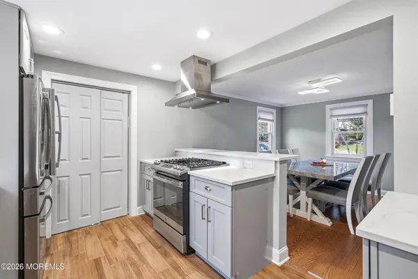 a kitchen with a stove a refrigerator and furniture