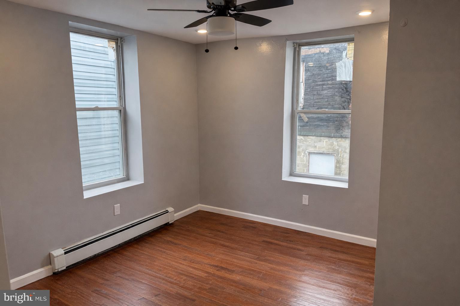 4548 North 17th Street Philadelphia, PA 19140 - Photo 11 of 13 an empty room with wooden floor fan and windows