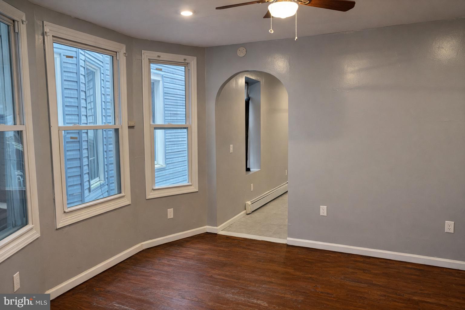 4548 North 17th Street Philadelphia, PA 19140 - Photo 4 of 13 an empty room with wooden floor chandelier and windows