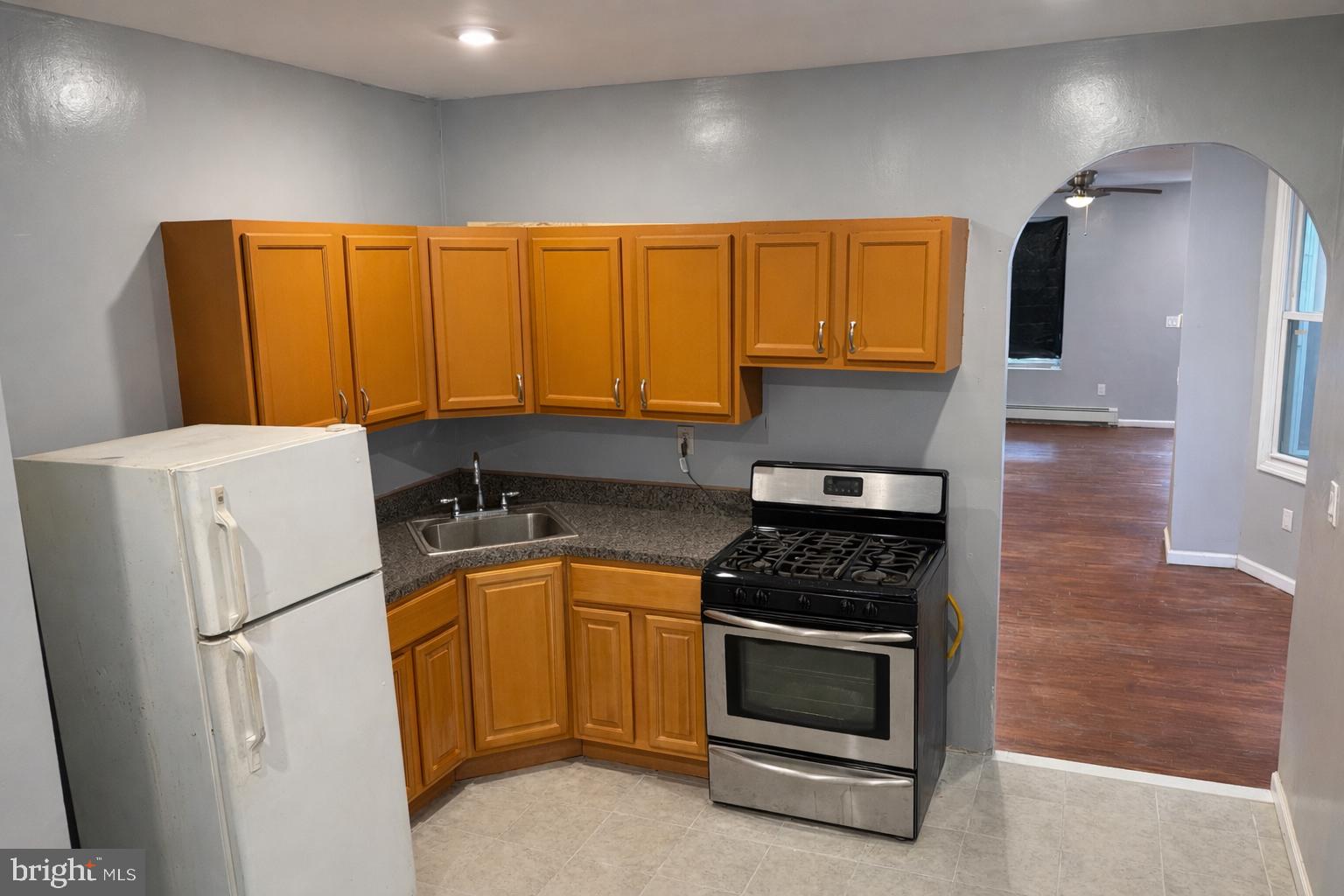 4548 North 17th Street Philadelphia, PA 19140 - Photo 6 of 13 a kitchen with a refrigerator a stove a sink and cabinets
