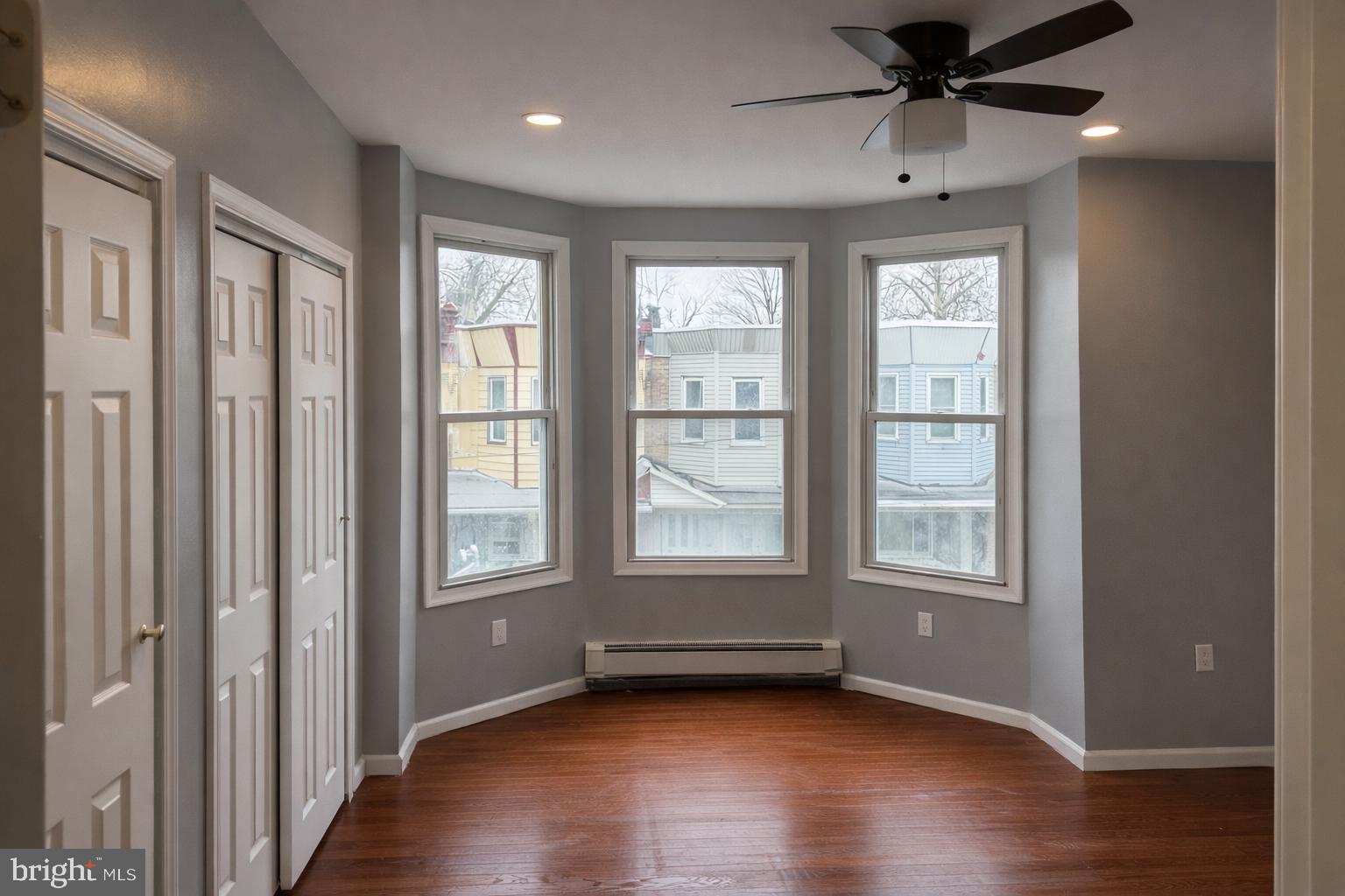 4548 North 17th Street Philadelphia, PA 19140 - Photo 8 of 13 an empty room with wooden floor fan and windows