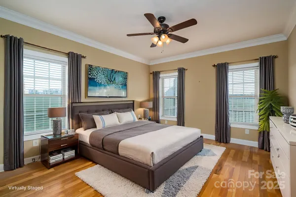 a bedroom with a large bed a chandelier and a window