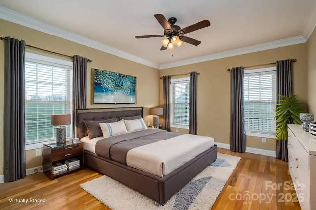 a bedroom with a large bed a chandelier and a window