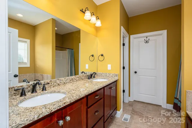 a bathroom with a granite countertop sink and a mirror