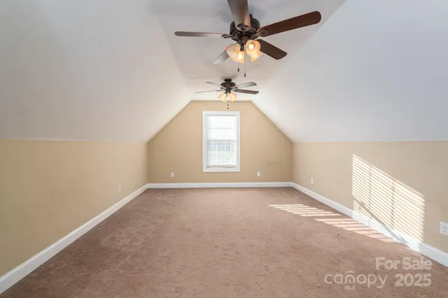 an empty room with a window and a ceiling fan