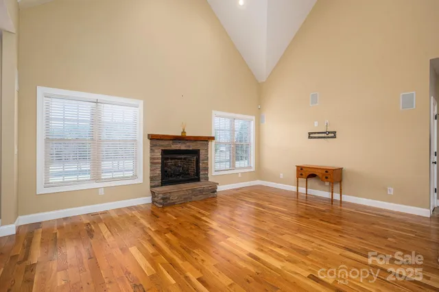a view of an empty room with a fireplace and a window