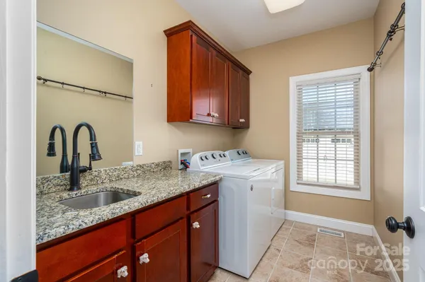 a utility room with a sink a vanity and a window