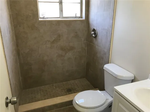 a white toilet sitting next to a bath tub and a shower