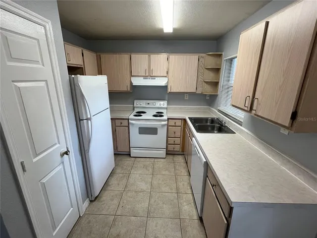 a kitchen with a stove a refrigerator and a sink