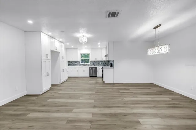 a kitchen with granite countertop a stove and a wooden floors