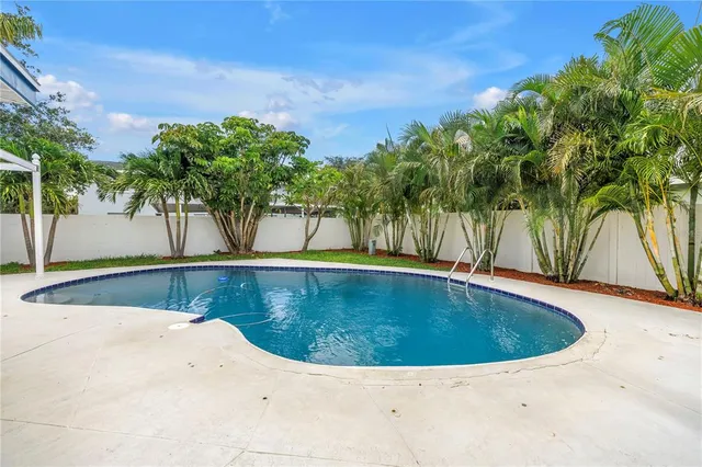 a backyard of a house with potted plants and large tree