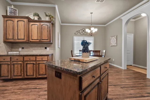 a kitchen with stainless steel appliances granite countertop a kitchen island a stove and a sink
