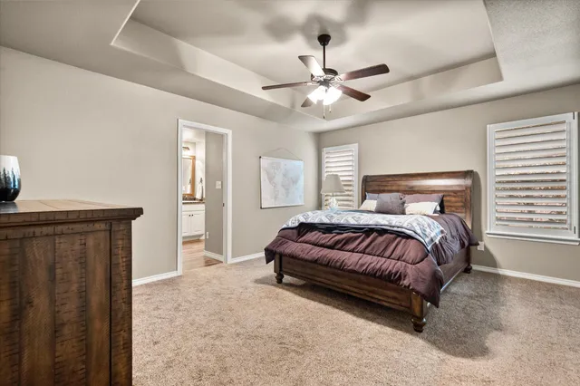 a spacious bedroom with a bed and a chandelier