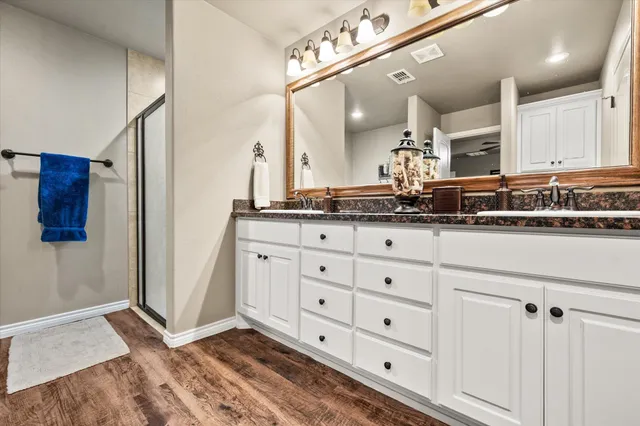a spacious bathroom with a granite countertop sink and a mirror