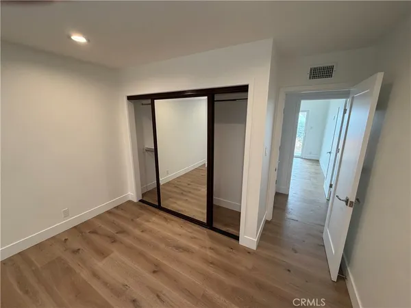 an empty room with wooden floor and entrance