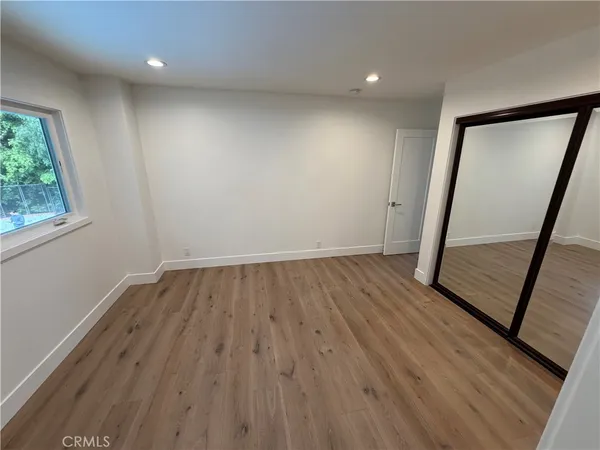 wooden floor in an empty room with a mirror