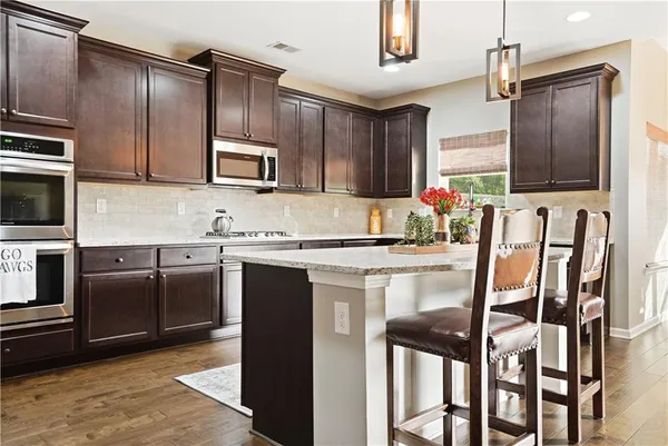 a kitchen with stainless steel appliances granite countertop a stove top oven a sink and dishwasher