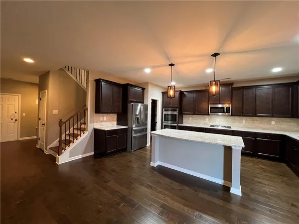 a large white kitchen with lots of counter space a sink and appliances