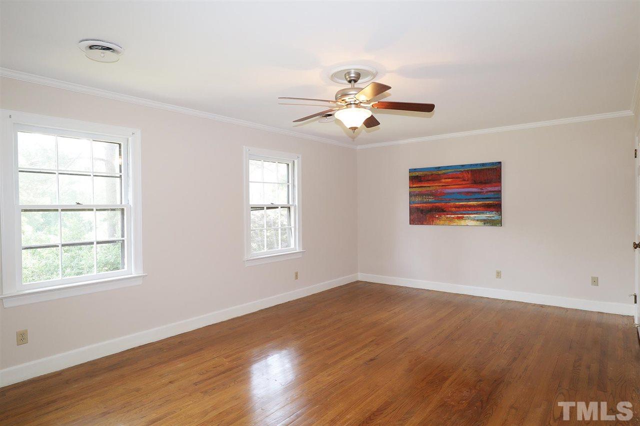 6709 Foxfire Place Raleigh, NC 27615 - Photo 18 of 24 a view of an empty room with a window and wooden floor