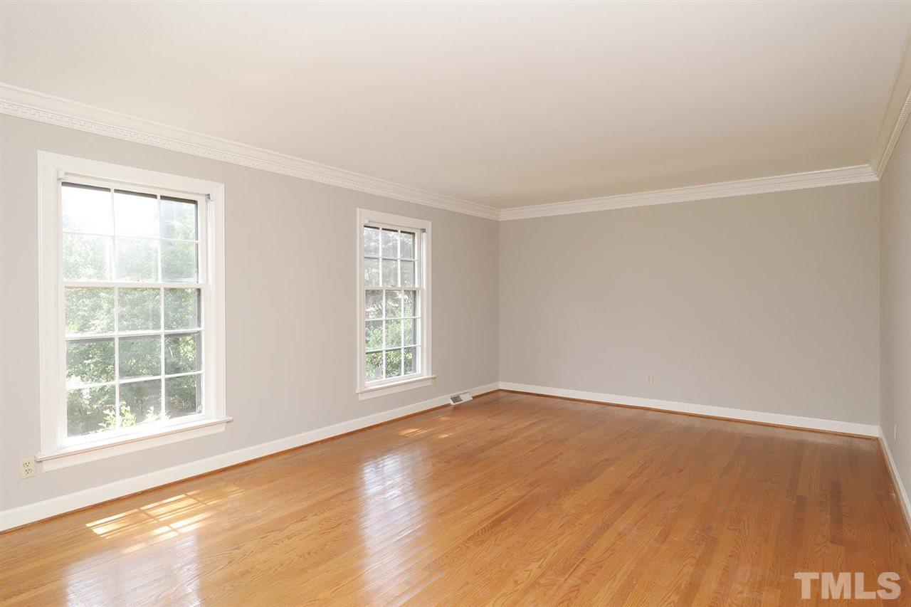6709 Foxfire Place Raleigh, NC 27615 - Photo 5 of 24 an empty room with wooden floor and windows
