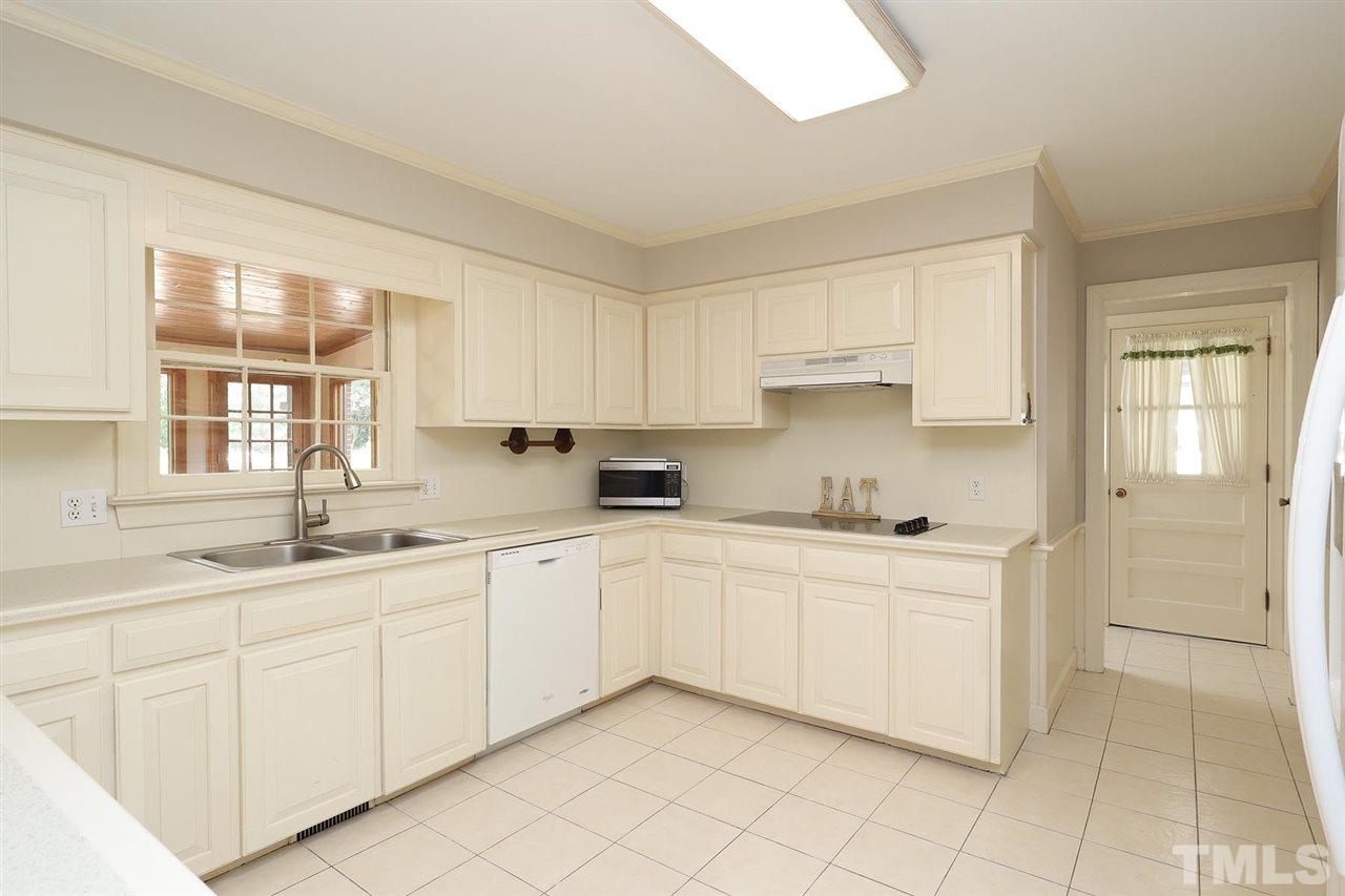 6709 Foxfire Place Raleigh, NC 27615 - Photo 8 of 24 a kitchen with white cabinets a sink and dishwasher