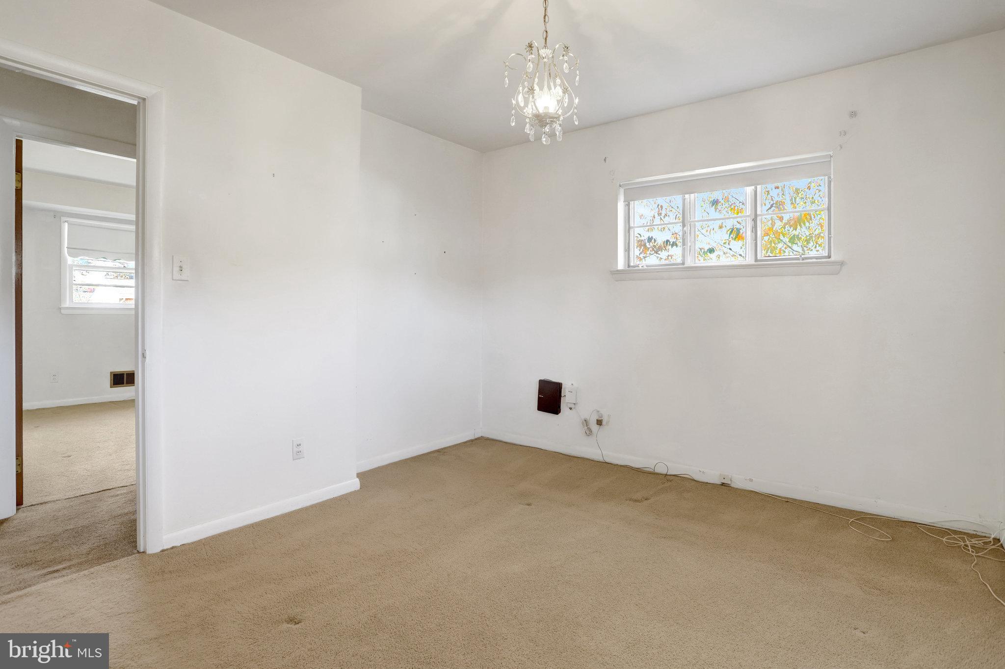 6928 Ruskin Street Springfield, VA 22150 - Photo 13 of 34 an empty room with a chandelier fan and windows