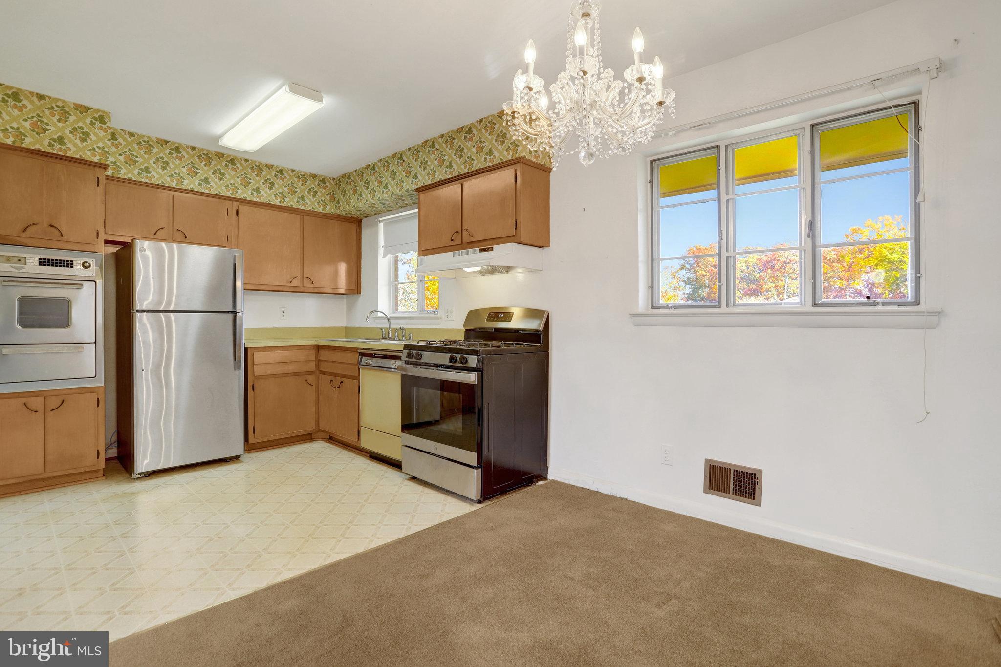 6928 Ruskin Street Springfield, VA 22150 - Photo 6 of 34 a kitchen with stainless steel appliances granite countertop a stove a sink dishwasher and a refrigerator