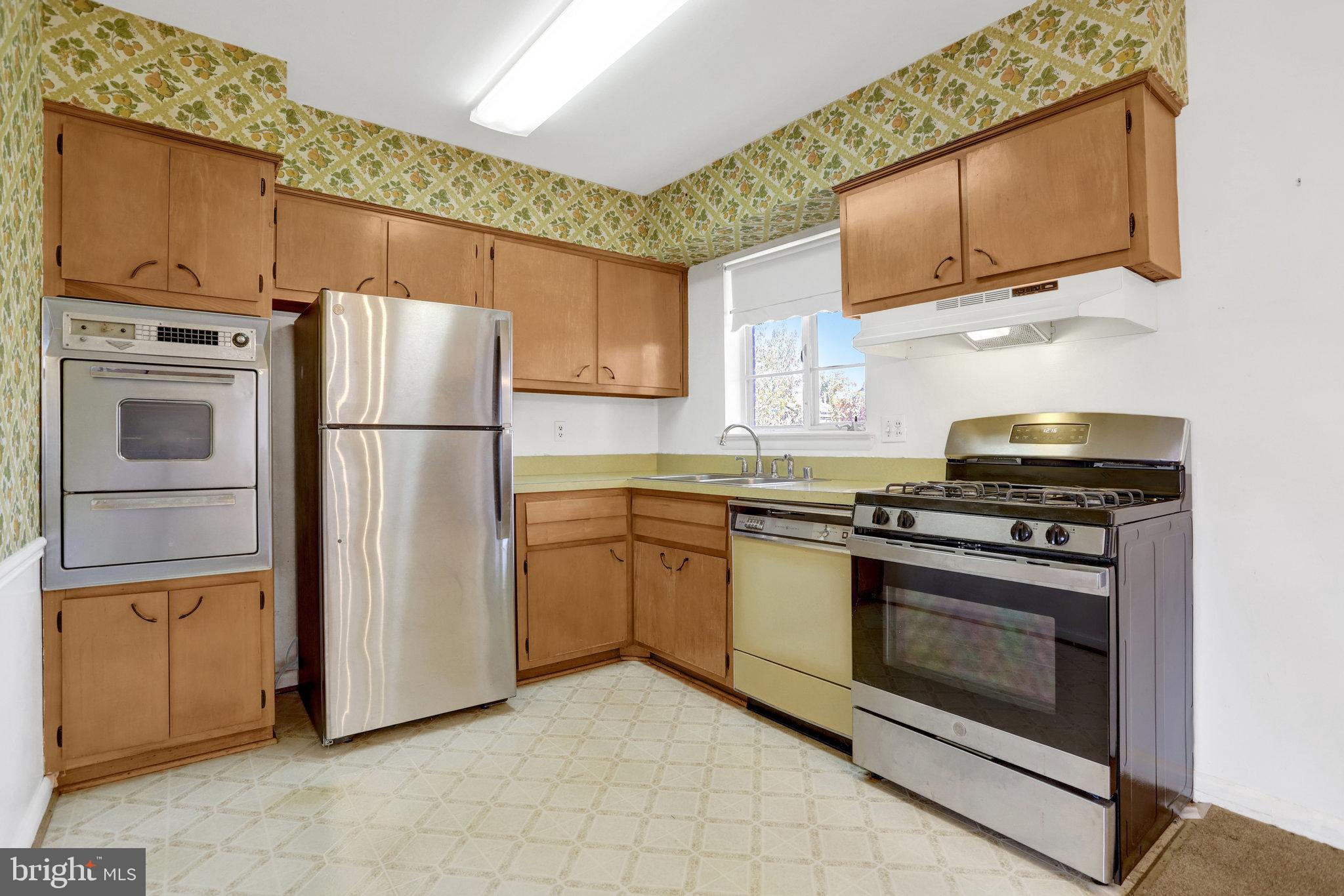 6928 Ruskin Street Springfield, VA 22150 - Photo 8 of 34 a kitchen with appliances a refrigerator a stove a microwave and cabinets