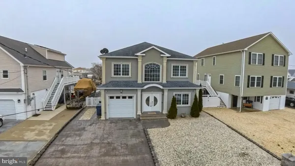 a front view of a house with a yard and parking space