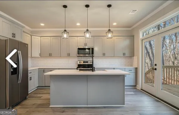 a kitchen with kitchen island a sink stainless steel appliances and cabinets