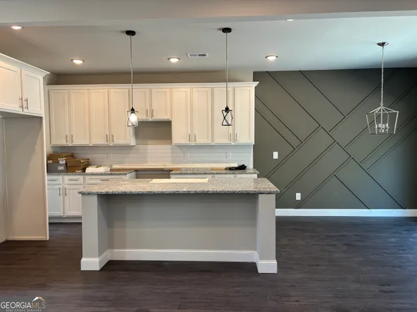 a kitchen with a sink cabinets and wooden floor