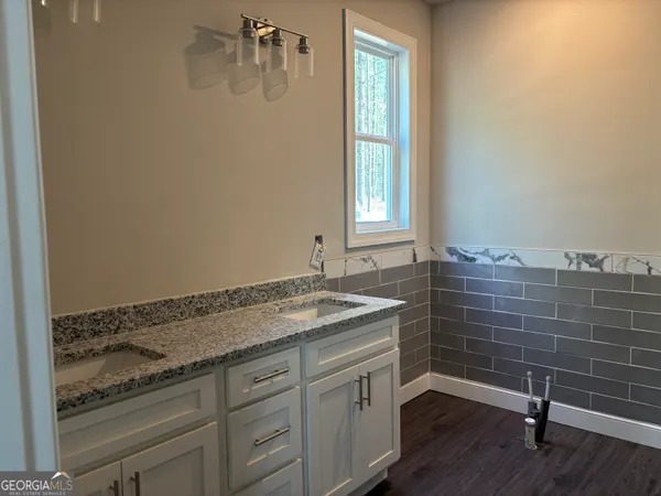 a bathroom with a granite countertop sink and white cabinets
